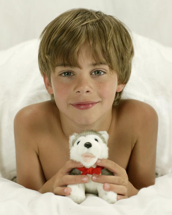 在床上拿着玩具的小男孩图片
