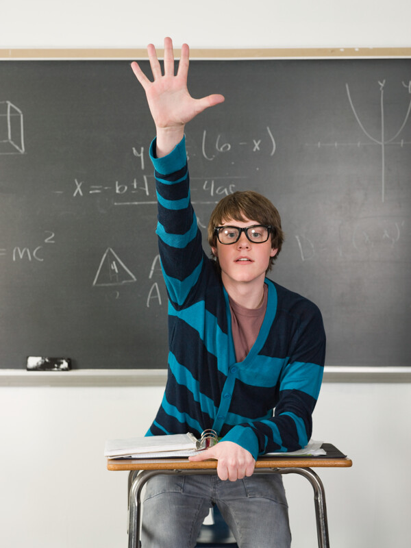 教室戴眼镜男孩举手发言图片