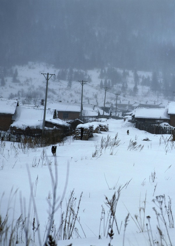 白雪覆盖的山下村庄图片