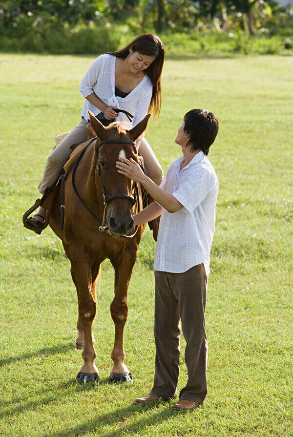 草坪上练习骑马的情侣图片图片