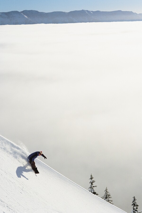 高山下滑的滑雪运动员图片