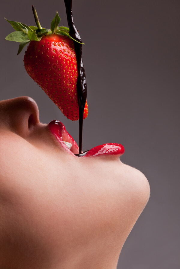 吃草莓巧克力的女孩特写图片