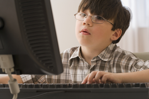 载着眼镜玩电脑的小男生图片