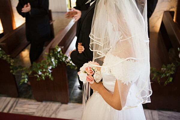 穿着白色婚纱手拿花朵幸福微笑的新娘俯视图图片