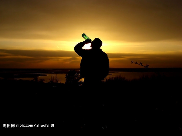 黄昏下海边喝酒的男人图片