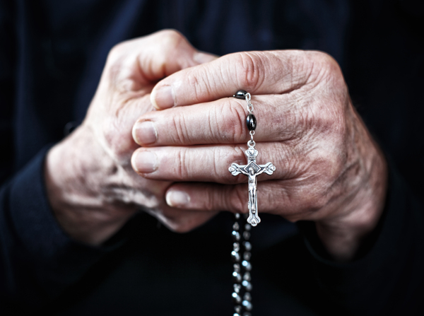 手拿十字架祈祷的老人图片