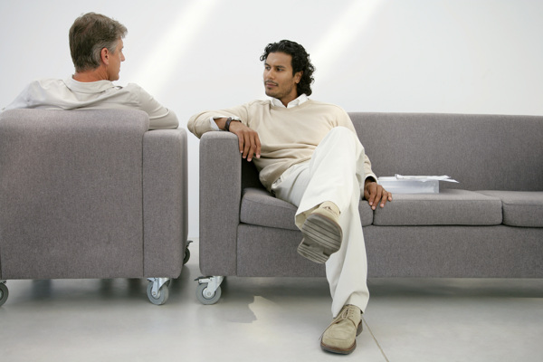 办公室坐在沙发上对着交谈的男人图片图片