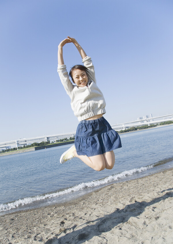 沙滩跳跃的快乐女生图片